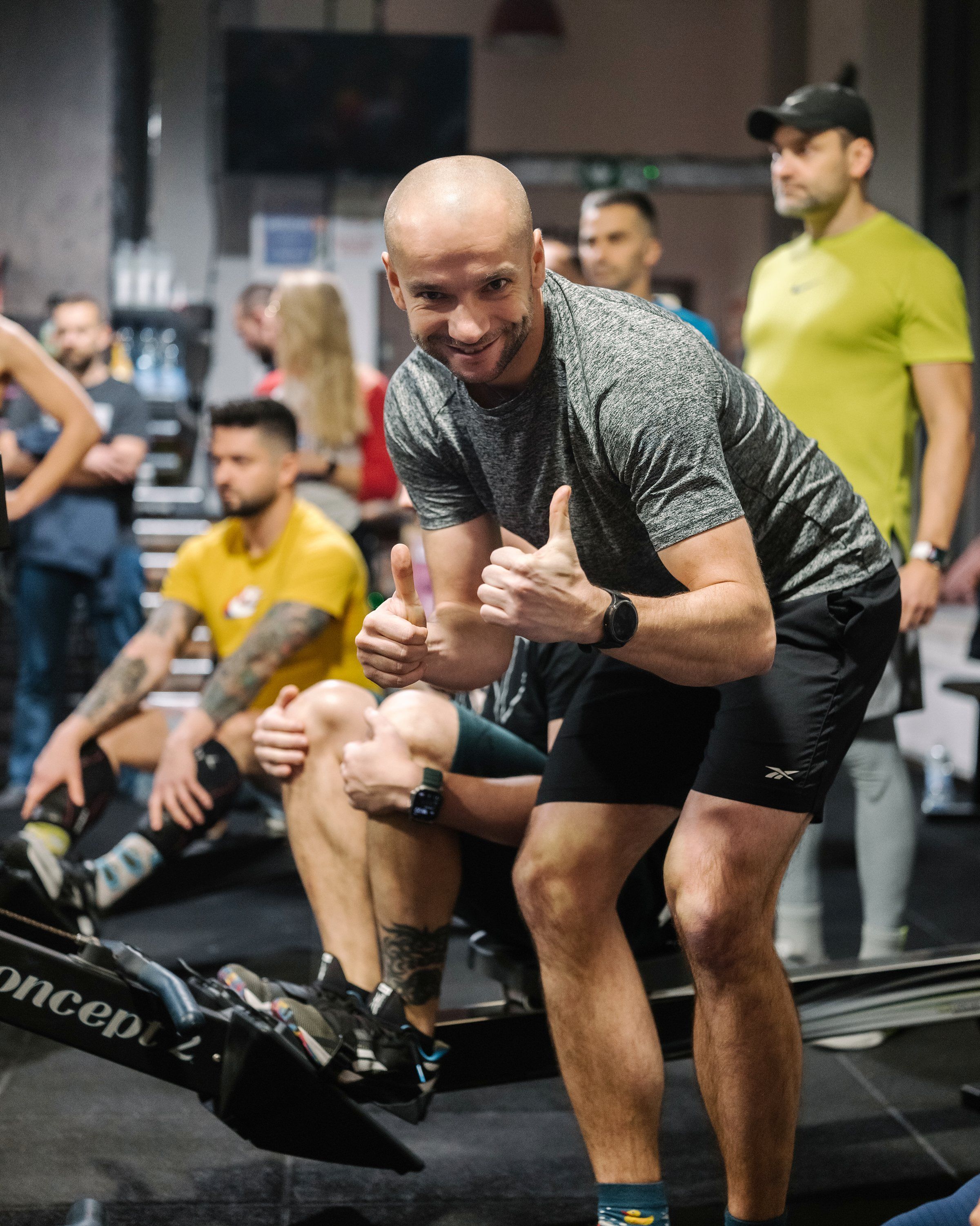 Uśmiechnięty mężczyzna pokazuje dwa kciuki w górę podczas zajęć w CrossFit Wilanów