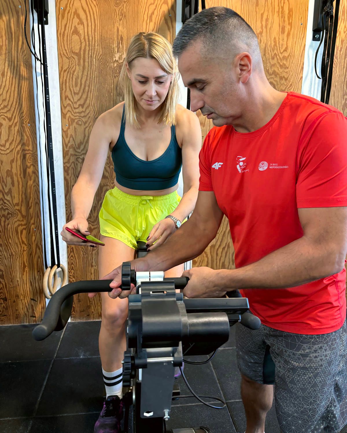 Trener ustawia rower treningowy w boksie CrossFit Wilanów
